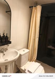 a bathroom with a white toilet and a sink at CBD Studio Loft 2A at City Center! in Medan +7 photos