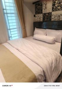 a bed with white sheets and pillows in a bedroom at CBD Studio Loft 2A at City Center! in Medan