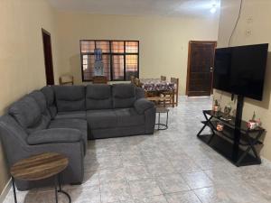a living room with a couch and a tv at Double S Vacation Home in Tamasopo