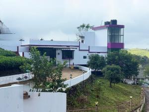 a white building with a control tower on a hill at HAVI Holidays in Vagamon