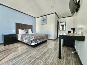 a hotel room with a bed and a desk at Guest Harbor Inn- Port Of Los Angeles San Pedro in San Pedro