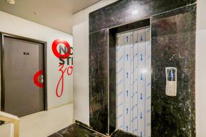 a room with a door with a cell phone on the wall at Collection O Le Noida Hotel Near Sector 76 Metro Station in Noida