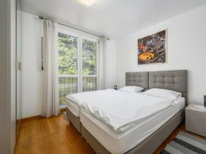 a white bedroom with a large bed and a window at Premium apartment Peschiera Porec in Poreč