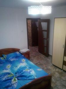 a bedroom with a bed with a blue comforter at Apartament Mery in Constanţa