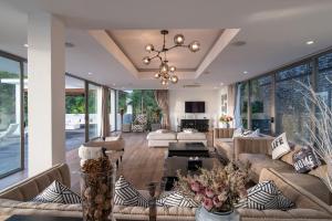 un ampio soggiorno con divani e lampadario a braccio di Seascape 6BR Prestige Villa Skyline Pool a Ban Nakhale