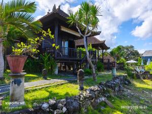 Un uomo in piedi di fronte a una casa di Sunrise Cottage Lembongan a Nusa Lembongan