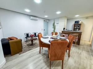 a living room with a table and chairs and a couch at Eg Jardim do Shopping apto 102 in Caxias do Sul