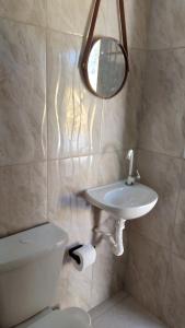 a bathroom with a toilet and a sink and a mirror at Pousada Araújo em Paraty 1 in Paraty