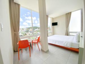 a bedroom with a bed and a table and chairs at Bazan Dalat Hotel in Da Lat