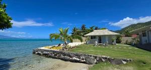 a house on the shore of a body of water at Villa Kahia in Teavaro