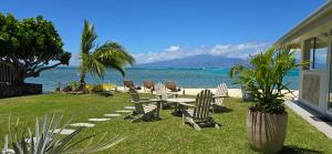 a table and chairs sitting on the grass near the ocean at Villa Kahia in Teavaro