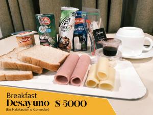 a table with a plate of food with bread and cheese at Sky Aloja Hotel - Ex H Bilbao in Osorno
