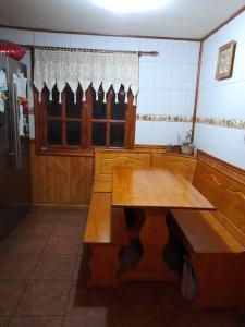 a kitchen with a wooden table and a window at Hospedaje de la Abu in Coihaique
