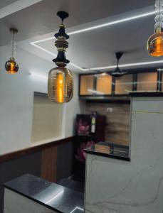 une cuisine avec trois lumières suspendues au plafond dans l'établissement 2 bhk luxury independant heritage villa, à Trivandrum