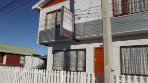 a white picket fence in front of a house at Casa Hospedaje Costanera in Puerto Natales