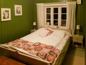 Schlafzimmer mit einem Bett mit grünen Wänden und einem Fenster in der Unterkunft Family Cabin By The Fjord In Tysnes in Uggdalseidet + 10 Fotos