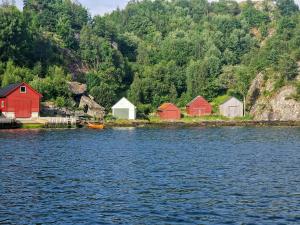 eine Gruppe von Häusern am Ufer eines Gewässers in der Unterkunft Family Cabin By The Fjord In Tysnes in Uggdalseidet