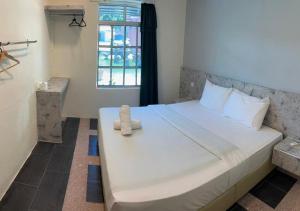a bedroom with a bed with a teddy bear on it at D'Lima Beach Inn in Pantai Cenang +105 photos