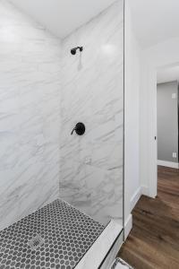 a shower in a bathroom with white marble at Modern Renovated 3-Bed Near Ann Arbor & Ypsilanti in Ypsilanti +32 photos