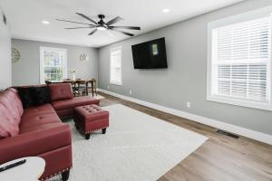 a living room with a red couch and a flat screen tv at Modern Renovated 3-Bed Near Ann Arbor & Ypsilanti in Ypsilanti
