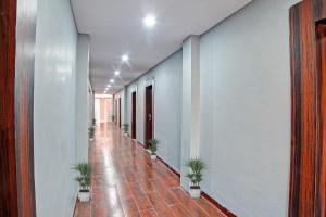 an empty hallway with potted plants in a building at Palette - The Mark Club & Resorts in Durg