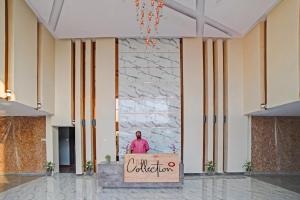 a man standing behind a box in a lobby at Palette - The Mark Club & Resorts in Durg