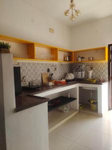 a kitchen with yellow cabinets and a counter top at DREAMY cosy stay 4bhk, 6 mins to Whitetown & Beach - COPPER in Puducherry