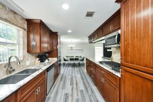 コンローにある4-BR Family Retreat in Quiet Conroe Neighborhoodの大きなキッチン(木製キャビネット、シンク付)