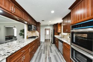 コンローにある4-BR Family Retreat in Quiet Conroe Neighborhoodの大きなキッチン(木製キャビネット、大理石のカウンタートップ付)