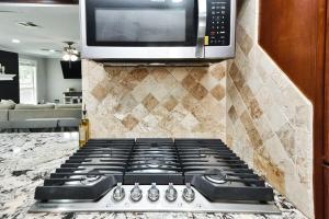 コンローにある4-BR Family Retreat in Quiet Conroe Neighborhoodのキッチン(コンロ、上部に電子レンジ付)