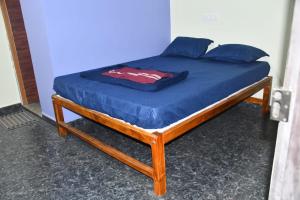 a bed with a blue sheet and pillows on it at Golden Kudle Beach Resort in Gokarna