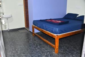 a bed with a blue comforter on it in a room at Golden Kudle Beach Resort in Gokarna