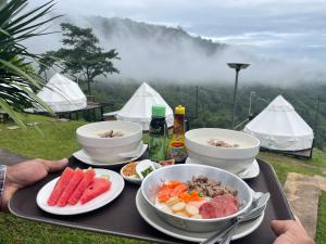 una bandeja de comida con tazones y platos de comida en Merry Camp Khaokho, en Khao Kho