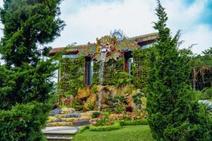 a garden with a fountain in front of a building at The Blooms Villas in Bedugul +28 photos