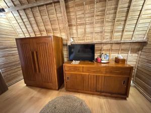a room with a tv on top of a wooden cabinet at The Blooms Villas in Bedugul