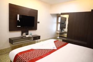 a hotel room with a bed and a flat screen tv at pvp inn in Ārani