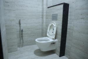 a bathroom with a white toilet in a stall at pvp inn in Ārani