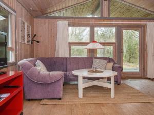 a living room with a purple couch and a table at 6 person holiday home in Glesborg-By Traum in Fjellerup