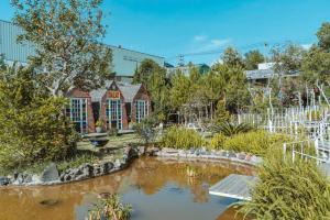 a garden with a pond in front of a building at In The Pines Homestay & Coffee in Da Thanh