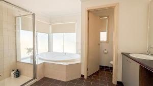 a bathroom with a bath tub and a window at StayAU Family Haven Pet-Friendly Caroline Springs in Caroline Springs