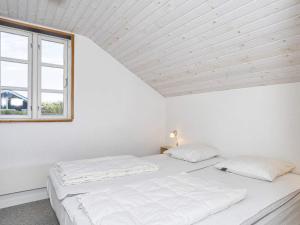 a white bedroom with a bed and a window at 6 person holiday home in Nibe in Nibe +13 photos