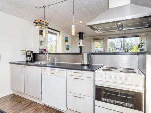 a kitchen with a stove and a sink at 6 person holiday home in Nibe in Nibe