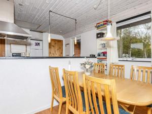 a kitchen and dining room with a wooden table and chairs at 6 person holiday home in Nibe in Nibe