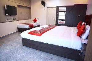 a bedroom with two beds and a flat screen tv at pvp inn in Ārani