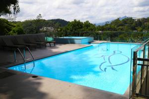 a large swimming pool with blue water at The Dorwin Heights in Kandy