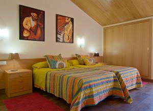 um quarto com uma cama com um cobertor colorido em Hotel Pinxo em Santa Coloma de Farners