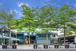 a building with trees in front of it at Dekang Yuexiang Hotel in Guangzhou