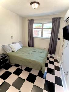 a bedroom with a bed and a checkered floor at Central Tampa Hot Spot! in Tampa