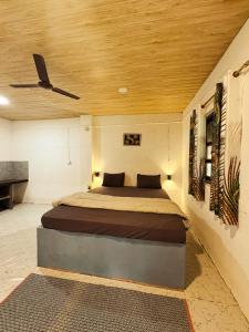 a bedroom with a bed with a ceiling fan at shanti MIZU in Arambol