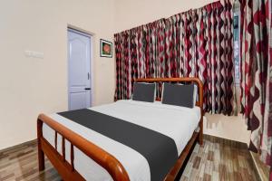 a bedroom with a bed in a room with curtains at Kodai Mist with Pick up & Drop in Kodaikānāl